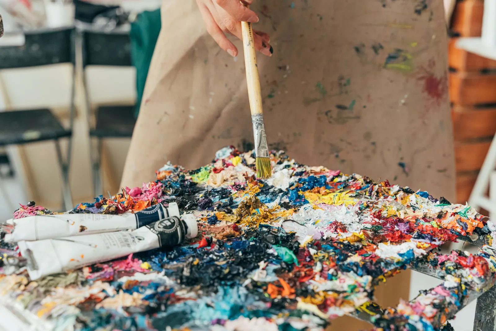 Artist mixing paint on a palette, for Antigua Art Week workshops and studio visits