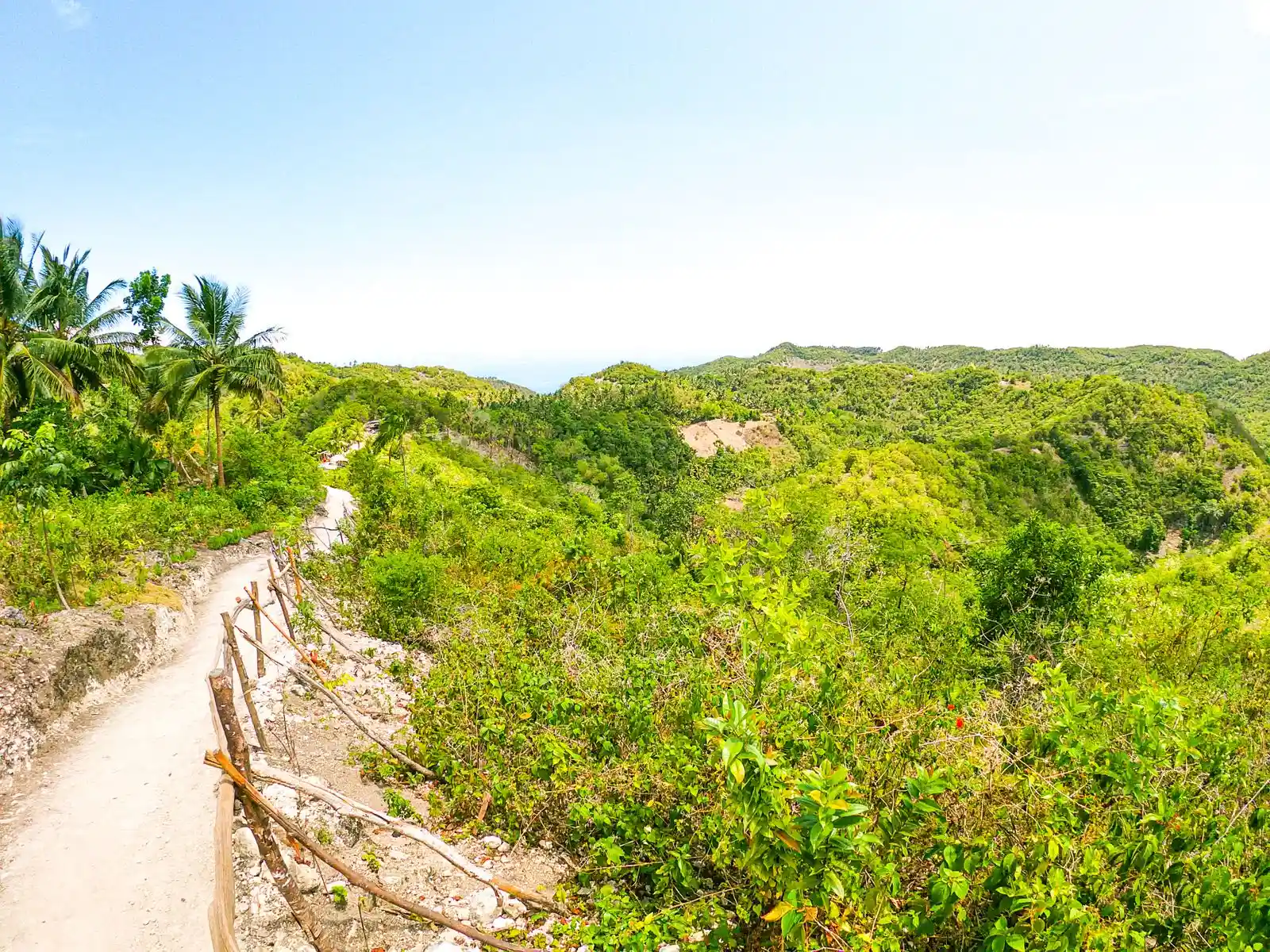 Hiking trail through green tropical hills on a clear day