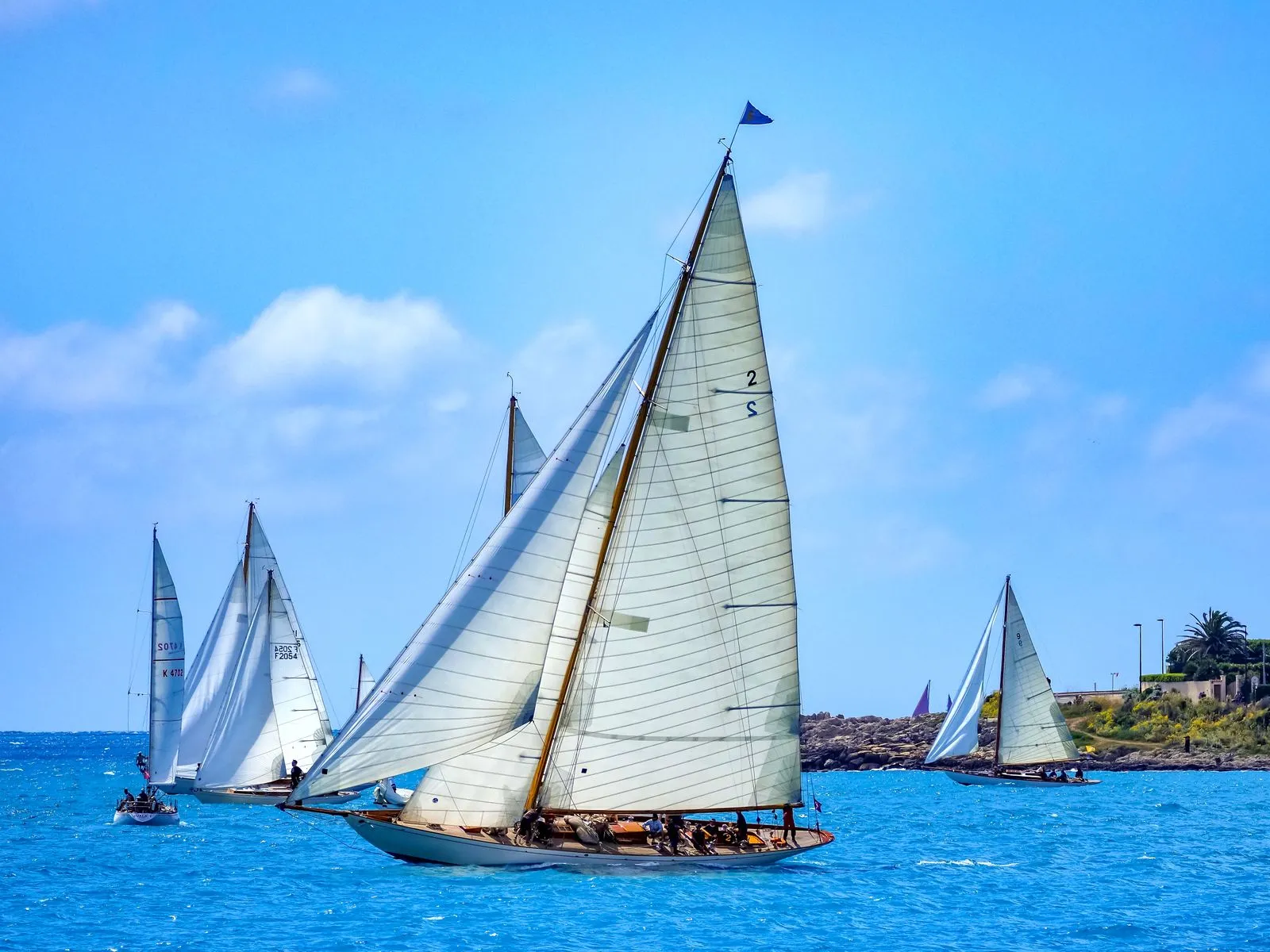 Classic wooden sailing yachts racing under full sail in a regatta