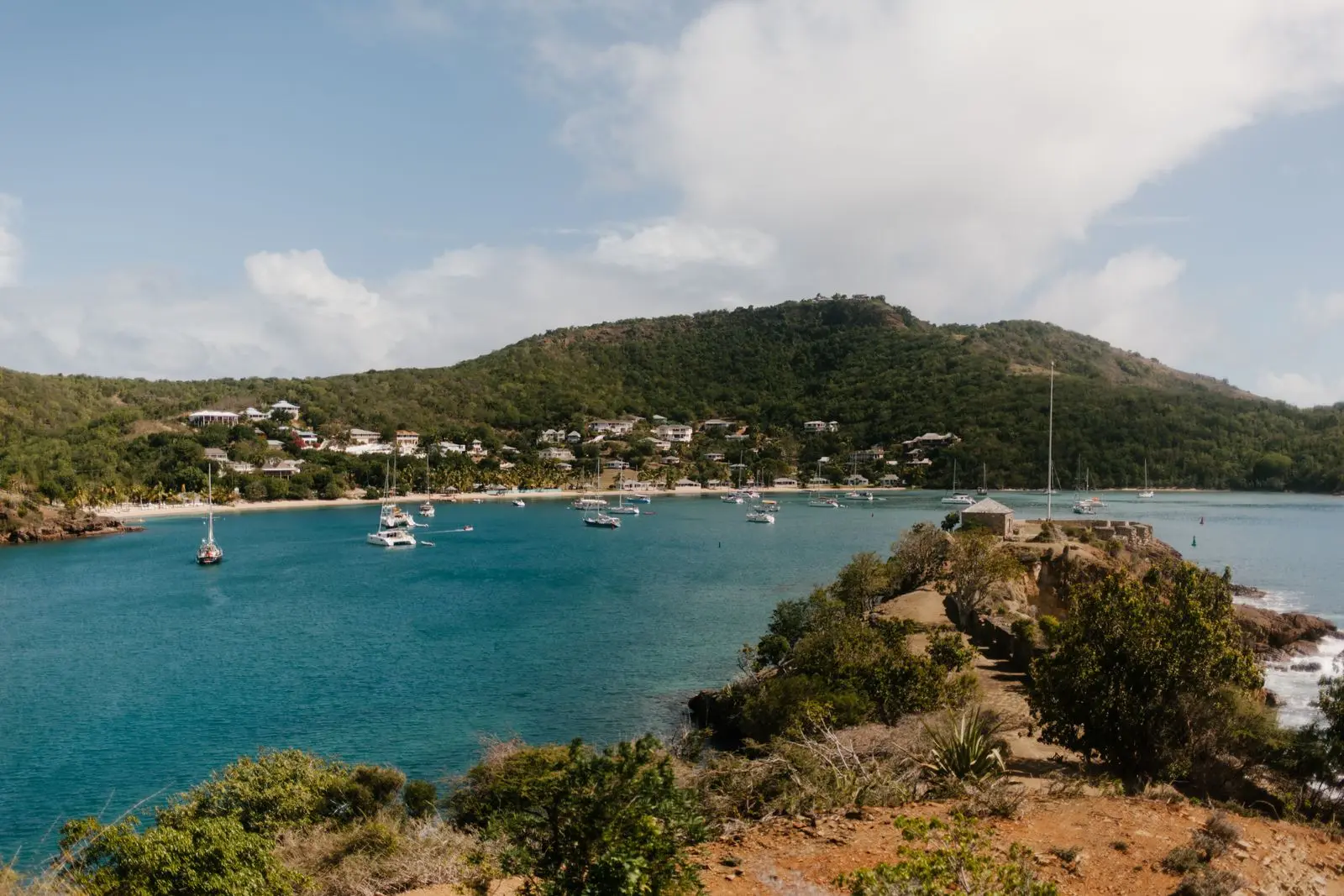 Sailboats anchored in a green bay on Antigua's south coast seen from a headland