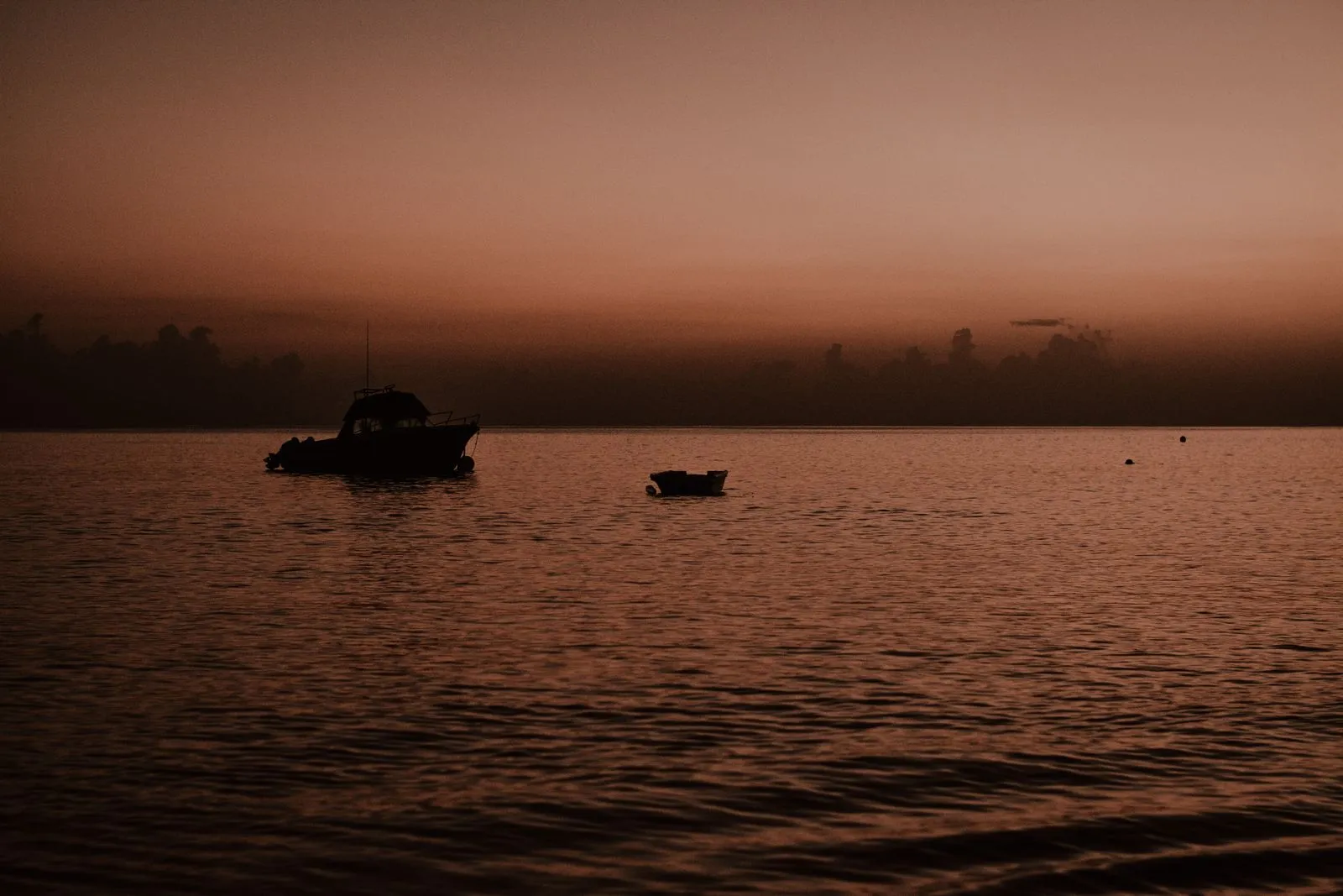 Boats silhouetted on calm water at sunset in Antigua and Barbuda